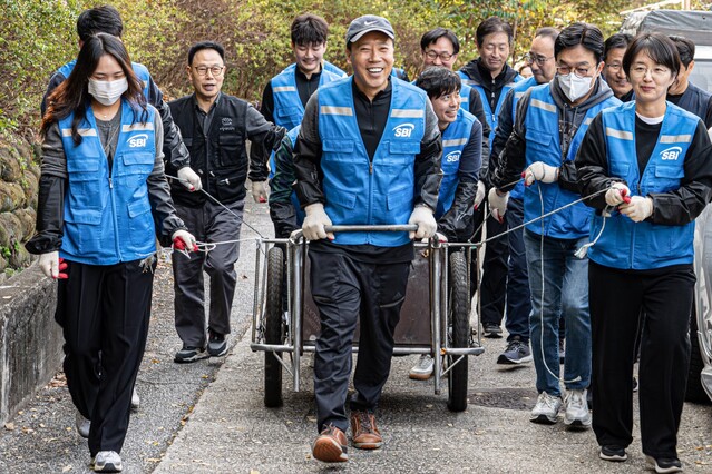 ▲ SBI저축은행 김문석 대표이사가 SBI희망나눔 봉사단원들과 함께 연탄을 배달하고 있다.ⓒSBI저축은행