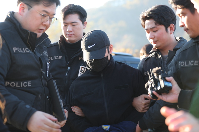 ▲ 6일 강원 화천군 북한강에서 함께 근무하던 여성 군무원을 살해한 뒤 시신을 훼손하고 북한강에 유기한 현역 군 장교 A(38)씨에 대한 현장 검증이 진행됐다. 사진은 A씨가 호송차에서 내려 취재진 질문에 묵묵부답하는 모습. ⓒ연합뉴스