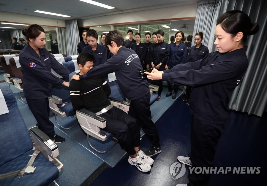 ▲ 대한항공 객실훈련센터에서 승무원들이 테이져건과 타이랩, 포승줄 등을 이용해 기내 난동 승객 제압 모의 훈련을 하고 있다. ⓒ연합뉴스