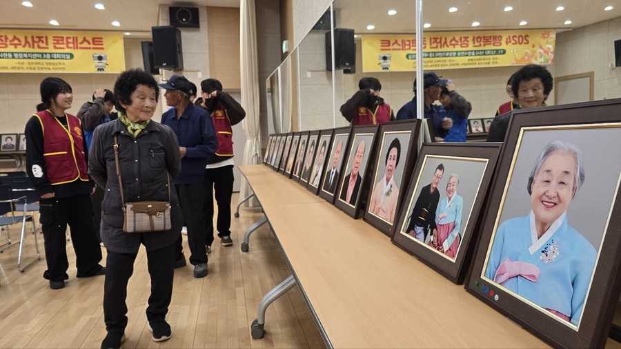 ▲ 청주대학교 영화영상학과 학생들이 ‘행복한 장수 사진’ 촬영을 진행한 가운데 12일 율량사천동 행정복지센터서 열린 ‘행복한 장수 사진’ 콘테스트 및 시상식에서 어르신들이 전시된 사진을 보고 있다.ⓒ청주대학교