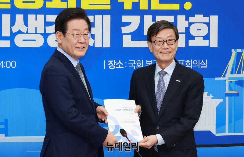 ▲ 윤진식 한국무역협회장이 20일 서울 여의도 국회에서 열린 경제 활성화를 위한 더불어민주당-한국무역협회 민생경제 간담회에서 이재명 더불어민주당 대표에게 무역업계 건의, 애로 건의문을 전달하며 기념촬영하고 있다. ⓒ 이종현 기자