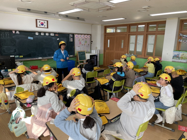 ▲ 울진 죽변초등학교 학생들이 어린이용 경안전모를 착용하고 안전 교육을 받고 있다. ⓒ현대건설