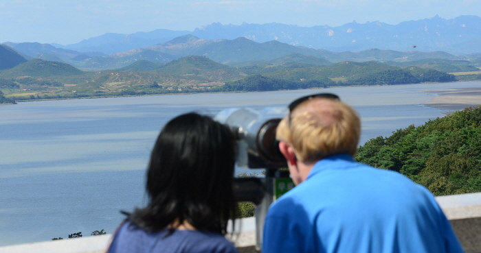 ▲ 북한이 평양시 순안 일대에서 일본 상공을 지나 북태평양 해상으로 불상 탄도미사일을 발사한 지난 2017년 9월 15일 오후 경기도 파주시 오두산 통일전망대를 찾은 외국인 관광객들이 북한 황해북도 개풍군 마을을 살펴보는 모습. ⓒ뉴시스