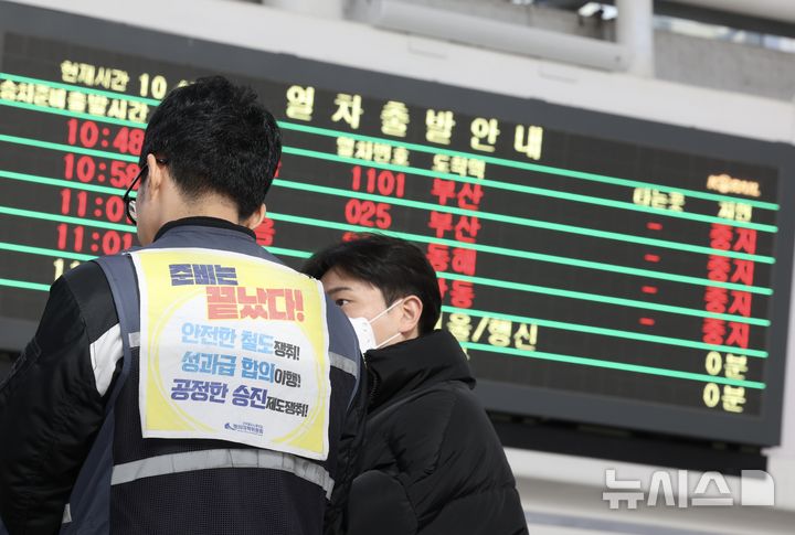 ▲ 전국철도노동조합이 총파업에 돌입한 지난 5일 오전 서울 용산구 서울역에서 한 철도노조 조합원 뒤로 일부 열차 중지 안내가 보이고 있다.ⓒ뉴시스