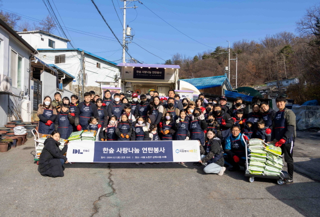 ▲ DL이앤씨 임직원 가족들이 서울 노원구 상계동에서 '사랑나눔 연탄 봉사활동'을 마친 뒤 기념촬영을 하고 있다. ⓒDL이앤씨