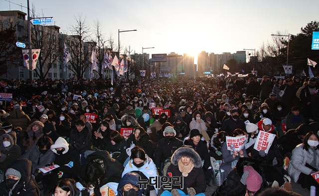 ▲ 윤석열 대통령 탄핵소추안 2번째 표결일인 14일 오후 국회의사당 앞에서 열린 탄핵찬성 집회에서 참가자들이 개표방송을 지켜보고 있다. 사진=서성진 기자. ⓒ뉴데일리