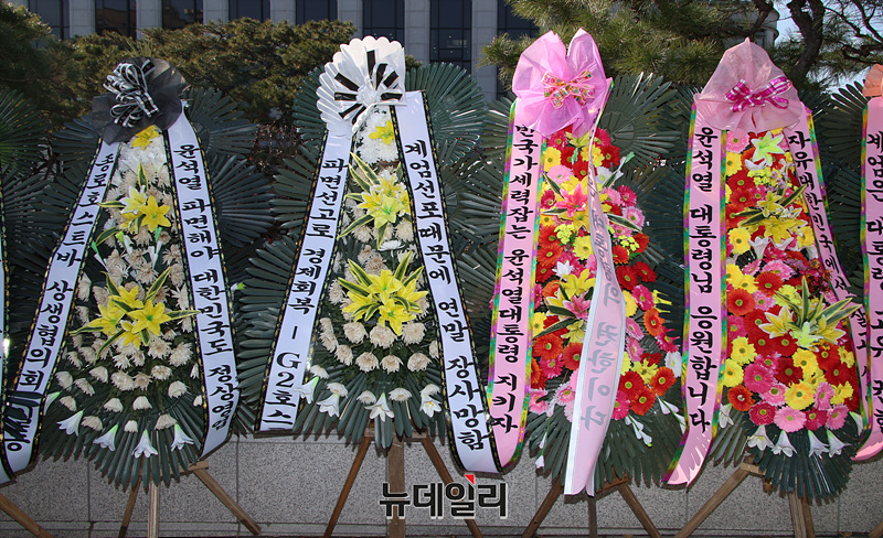 ▲ 윤석열 대통령 탄핵심판 1차 변론준비기일을 앞둔 17일 오후 서울 종로구 헌법재판소 앞에 시민들이 보낸 탄핵 찬성 화환과 반대 화환이 놓여있다. ⓒ서성진 기자