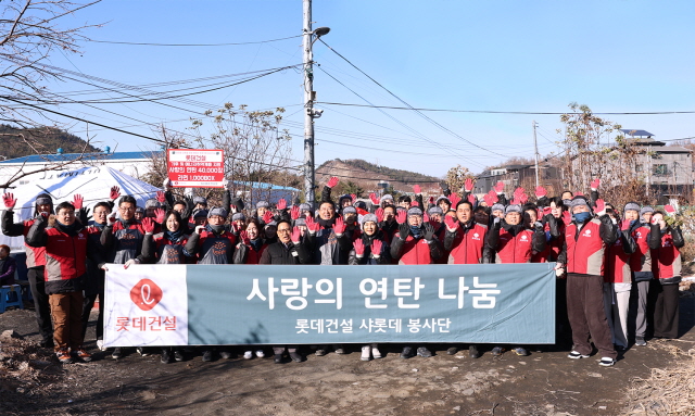 ▲ 롯데건설 임직원이 사랑의 연탄 나눔 봉사 기념촬영을 하고 있다. ⓒ롯데건설