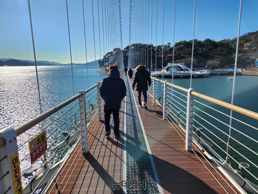 ▲ 12월 넷째 주 일요일인 22일 충남 예산군 예당호에서 관람객들이 날씨가 영하로 뚝 떨어지자 잔뜩 움크러든 가운데 출렁다리를 건네고 있다.ⓒ김정원 기자