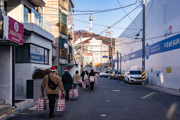 ▲ 민관학 연합봉사체 '용산 드래곤즈'의 산타 원정대 회원들이 선물 보따리를 들고 지역 아동복지시설을 찾아가고 있다.ⓒ숙명여대