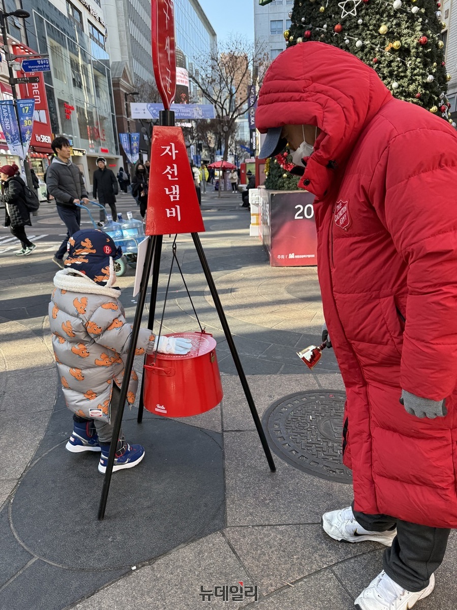 ▲ 크리스마스 이브인 24일 서울 중구 명동거리에서 영하의 날씨 속에서도 어린아이가 자선냄비에 기부를 하고 있다. 2024.12.24. ⓒ정혜영 기자