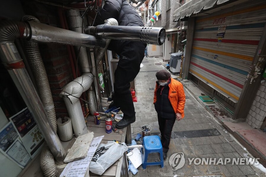 ▲ 서울 종로구 돈의동 쪽방촌에서 한 자원봉사자가 동파로 고장난 보일러를 수리하고 있다. ⓒ연합뉴스