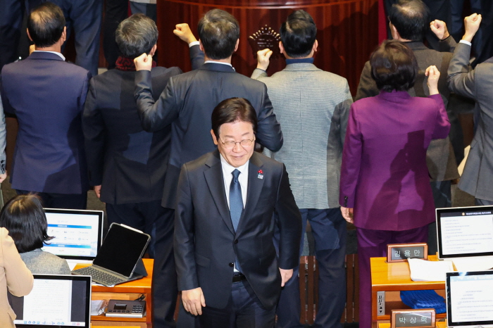 ▲ 이재명 더불어민주당 대표가 지난해 12월 27일 오후 서울 여의도 국회에서 열린 제420회국회(임시회) 제2차 본회의에서 국무총리(한덕수) 탄핵소추안 투표를 마친뒤 항의하는 국민의힘 의원들 뒤로 미소 지으며 이동하는 모습. ⓒ뉴시스