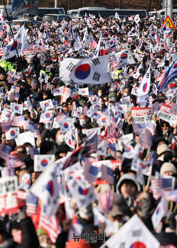 ▲ 3일 오후 서울 용산구 한남동 대통령 관저 앞에서 윤 대통령 지지자들이 체포조의 퇴각 소식에 태극기와 성조기를 흔들고 있다. ⓒ정상윤 기자