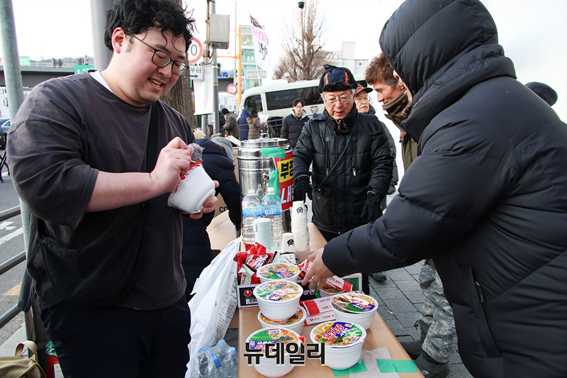 ▲ 8일 오후 서울 한남동 대통령 관저 인근에서 열린 탄핵 반대 촉구 집회에 자원봉사자로 참여한 2030 MZ 세대가 집회 참여자들을 위해 라면을 끓이는 모습. ⓒ서성진 기자