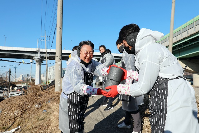 ▲ 하나생명 남궁원 사장이 지난 10일 경기도 광명 소하동 인근 쪽방촌에서 에너지 취약 계층의 따뜻한 겨울나기를 위한 연탄 나누기 봉사활동을 진행하며, 차례로 연탄을 건네고 있다.ⓒ사진 제공=하나생명