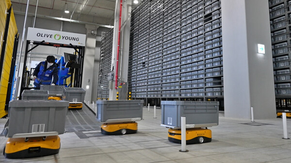 ▲ 물류 작업자가 자율 이동 로봇에 상품을 담고 있는 모습 ⓒCJ올리브영