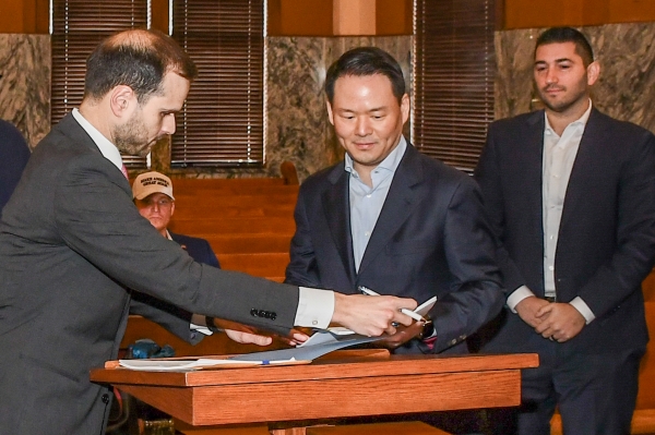 ▲ 1월27일(현지시각) 미국 텍사스주 존슨 카운티(Johnson County) 지방법원에서 진행된 파리바게뜨 제빵공장 투자 인센티브 조인식에서 허진수 SPC그룹 사장이(가운데) 서명을 하고 있다.ⓒSPC그룹