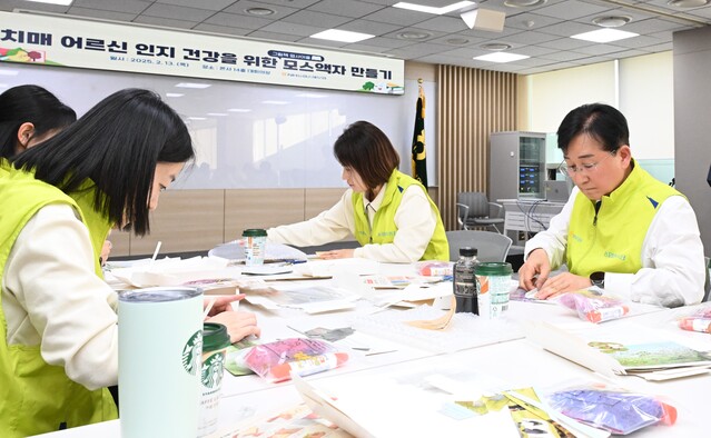 ▲ NH농협손해보험이 20일 공기정화액자 300개를 제작해 서울 은평구 치매안심센터에 전달했다. 송춘수 대표이사(사진 오른쪽)를 비롯한 ‘헤아림 봉사단’이 공기정화액자를 만들고 있다.ⓒNH농협손해보험