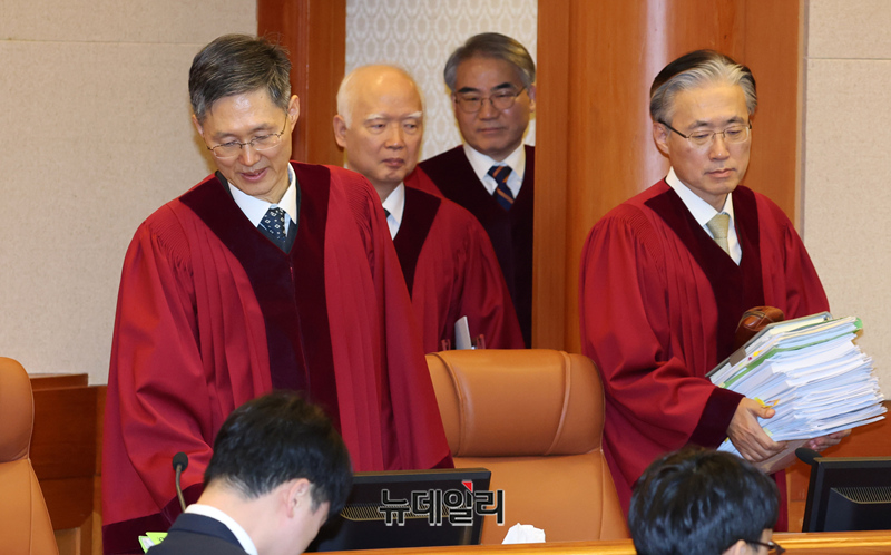 ▲ 문형배 헌법재판소장 권한대행을 비롯한 8명의 헌법재판관들이 심판정에 들어오고 있다. 한무더기 서류 덩어리를 들고 있다. 이들 손에 있는 것은 서류뿐만 아니다. 한국 법치주의 명줄도 쥐어져 있다. 법치주의는 죽을까, 기사회생할까. 그것이 문제다. ⓒ 공동취재단