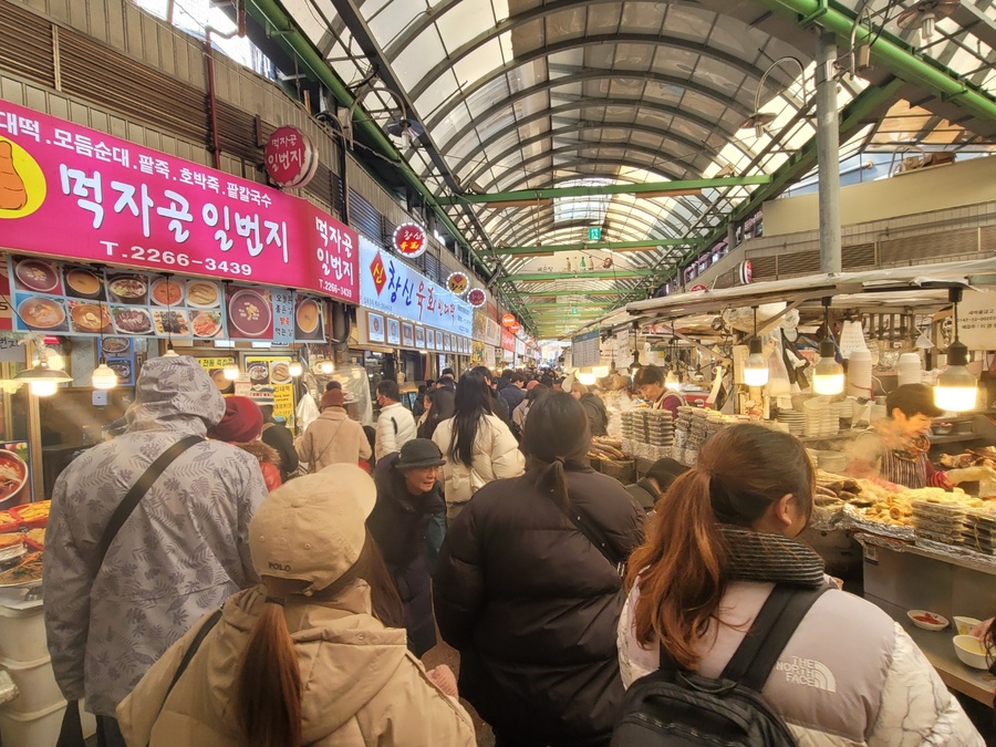 ▲ 지난 20일 점심시간인 12시경 광장시장은 사람들로 북적였다. 상인들은 각자 분주히 손님을 맞이하며, 시장 곳곳에서는 다양한 먹거리를 즐기려는 사람들의 발걸음이 끊이지 않았다. 특히, 전통적인 맛을 자랑하는 빈대떡과 같은 인기 먹거리를 찾는 이들로 인산인해를 이뤘다.ⓒ이미현 기자