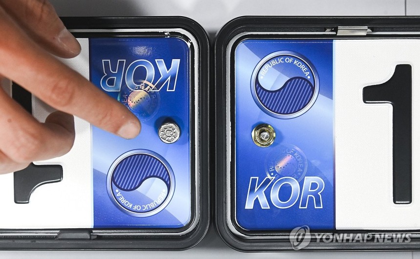 ▲ 자동차 등록번호판 봉인제도 폐지를 하루 앞둔 20일 경기 수원도시공사 수원시번호판제작소에서 관계자가 기존 스테인리스 마개로 봉인된 번호판(왼쪽)과 마개를 제거한 뒤 너트로 고정한 번호판을 보여주고 있다. ⓒ한국교통안전공단