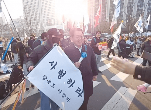 ▲ 김병주 더불어민주당 최고위원이 '사형하라 감옥도 아깝다'라는 대형 깃발을 든 지지자와 사진을 촬영하고 있다. ⓒ제보자 제공