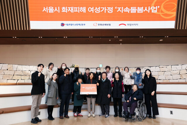 ▲ 한화손해보험 LIFEPLUS펨테크연구소 홍영진 파트장(첫째줄 왼쪽 5번째)이 24일 열린 ‘서울시 화재피해 여성가정 지속돌봄사업 전달식’에 희망브리지 김희윤 팀장(첫째줄 왼쪽 2번째), 서울소방재난본부 정태진 팀장(첫째줄 왼쪽 3번째)과 참석해 지원 대상자들과 기념촬영을 하고 있다.ⓒ한화손해보험