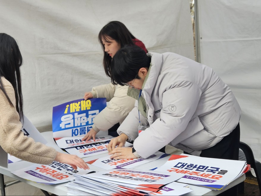 ▲ 행사 관계자들이 집회 시작 전 참가자들에게 피켓을 나눠주고 있다. ⓒ박서아 기자