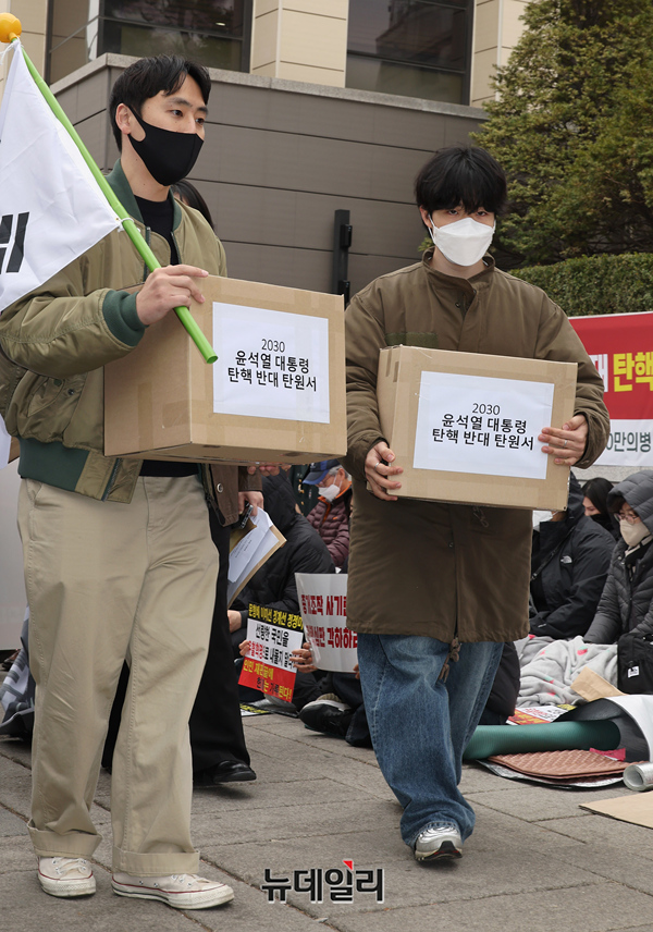 ▲ 기자회견을 마친 청년들은 탄원서가 담긴 박스를 들고 헌재로 줄지어 이동해 직접 제출했다. ⓒ정상윤 기자