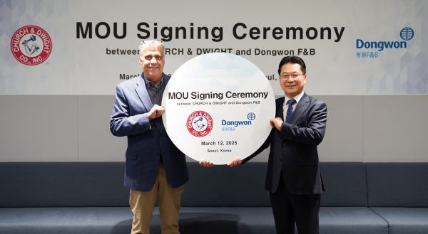 ▲ 12일 서울시 서초구 동원그룹 본사에서 강용수 동원F&B DNB본부장(오른쪽)과 아룬 히라난다니 처치앤드와이트 부사장(왼쪽)이 업무 협약을 맺고 기념 촬영을 하고 있다.ⓒ동원F&B