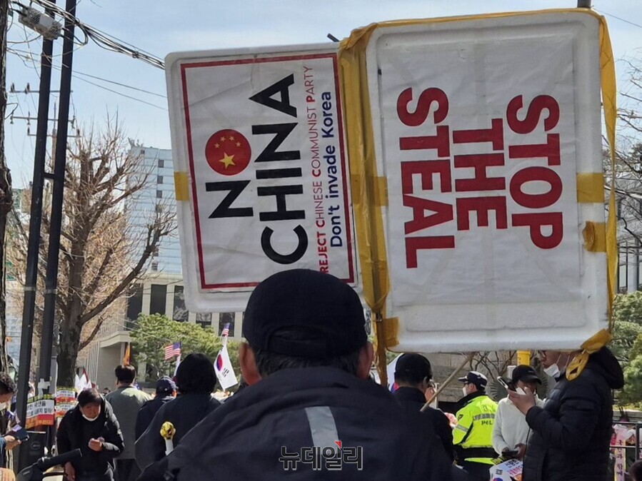 ▲ 13일 오후 서울 종로구 헌법재판소 인근에서 한 윤석열 대통령 지지자가 'STOP THE STEAL', 'NO CHINA'가 적힌 손팻말을 들고 있다. ⓒ김상진 기자