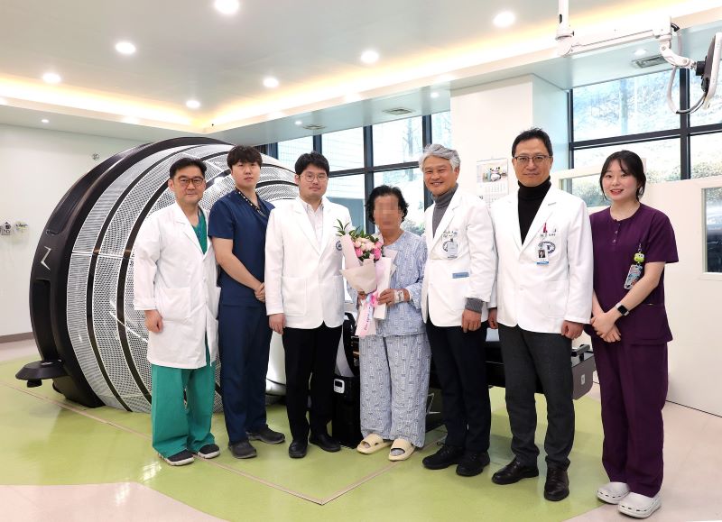 ▲ 단국대병원이 국내 최초로 도입한 자이로스콥(회전식) 방식의 방사선 수술장비 ZAP-X로 100번째 수술을 성공리에 마친 뒤 환자와 의사들이 기념촬영을 하고 있다.ⓒ단국대병원