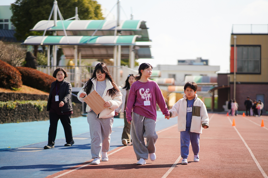 ▲ 서귀서초등학교의 6학년 학생이 1학년 학생과 함께 운동장을 걸으며 돌봄짝 활동을 첨여하고 있다. ⓒ제주특별자치도교육청 제공