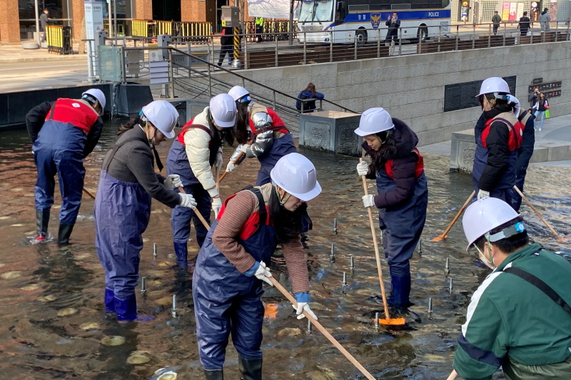 ▲ 서울 중구에 위치한 청계천의 바닥 퇴적물을 제거하고 있는 롯데마트와 슈퍼 임직원 모습ⓒ롯데마트