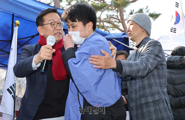 ▲ 윤석열 대통령 탄핵에 반대하는 한 고등학생이 20일 오후 서울 종로구 헌법재판소 앞에서 발언 직후 삭발을 하려하자 석동현 국민변호인단장과 시민들이 만류하고 있다. ⓒ정상윤 기자