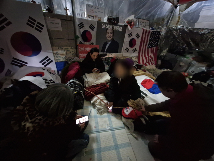 ▲ 김행 전 여성가족부 장관 후보자가 23일 자정 서울 종로구 헌재 옆 '애국진료소'에서 자원봉사자들과 담소를 나누고 있다. 이들의 뒤편으로는 노숙 투쟁 중인 김민서 국민의힘 익산갑 당협위원장과 박민식 전 국가보훈부 장관과 26일째 노숙·단식 투쟁 중인 전지영 국가정의실천연합 사무국장의 모습이 보인다. ⓒ조문정 기자