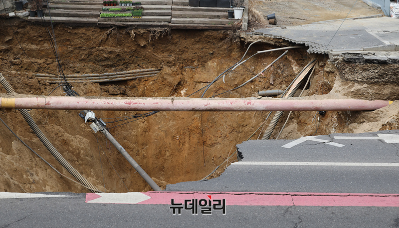 ▲ 서울 강동구 명일동에서 발생한 대형 땅꺼짐(싱크홀) 사고로 오토바이 운전자가 추락한 가운데 25일 오전 사고 현장에 소방당국의 안전 펜스가 쳐 있다. ⓒ정상윤 기자