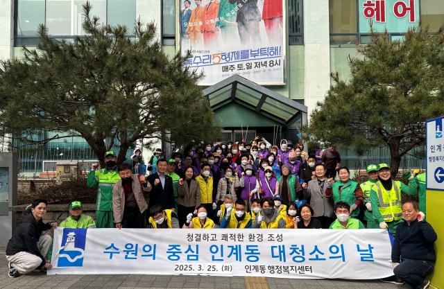 ▲ 수원 인계동 주민들이 25일 새봄맞이 일제 대청소를 실시한 뒤 기념촬영을 하고 있다. ⓒ수원시 제공
