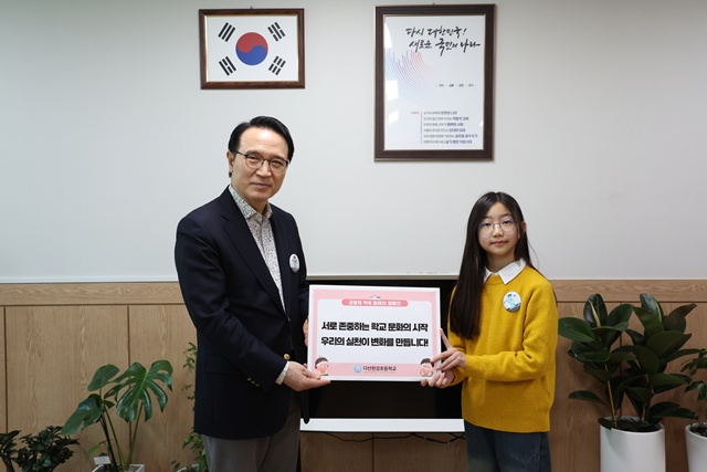 ▲ 임태희 경기도교육감(왼쪽)과 남양주 다산한강초등학교 학생이 26일 '공동체 약속 릴레이 캠페인'에 참여하고 있다. ⓒ경기도교육청 제공