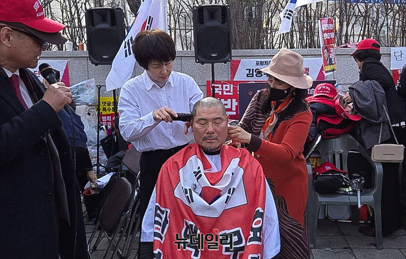 ▲ 시민단체 '부정선거방지대'(부방대) 상임위원을 맡고 있는 천창룡 씨가 지난 13일 오후 서울 종로구 헌법재판소 앞에서 열린 '대통령 국민변호인단'의 '무제한 필리버스터 기자회견' 현장에서 대통령 탄핵소추안 기각·각하를 촉구하며 삭발하는 모습. 천 씨의 삭발은 이번이 8번째다. ⓒ천창룡 씨 제공