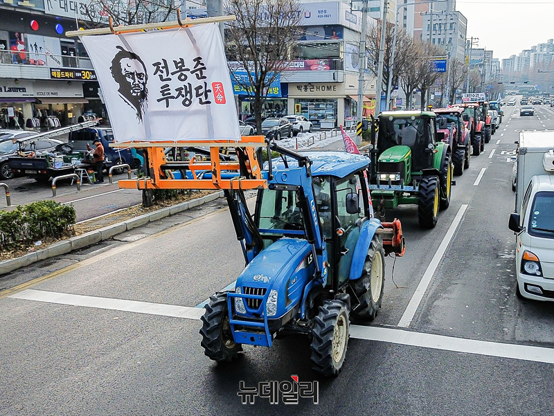 ▲ 지난해 12월21일 서울로 진입하려고 일반도로를 주행하는 전농의 농기계 행진. 농기계 앞에《전봉준투쟁단》이란 깃발이 펄렁인다. 농기계의 일반도로 주행은 불법이다. 그들은 자신들이《제2 동학난》을 벌이고 있다고 생각하고 있다. 그들 용어로는《동학농민전쟁》또는 《동학농민혁명》이다. 이념편향으로 똘똘 뭉친 역사학계 탓이다. ⓒ 서성진 기자