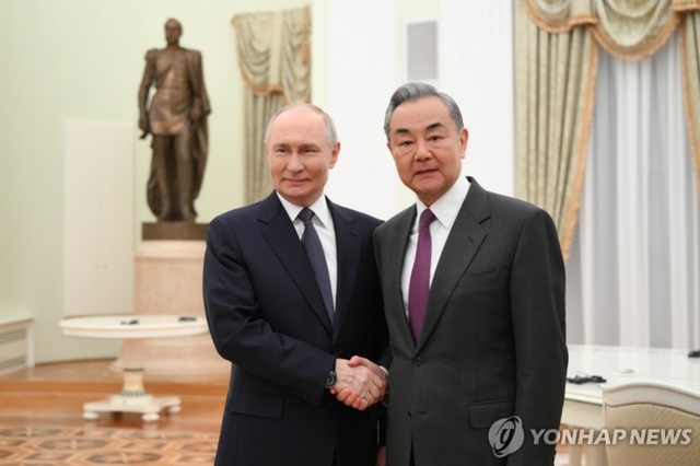 ▲ 블라디미르 푸틴 러시아 대통령(좌)이 크렘린궁에서 왕이 중국 외교부장을 만나 악수하고 있다. 250401 타스/크렘린 풀 연합뉴스. ⓒ연합뉴스