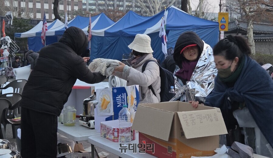 ▲ 3일 새벽 안국역 5번 출구 인근에서 탄핵 반대 철야 농성에 나선 시민들이 서로 컵라면과 커피를 건네며 아침을 맞고 있다. ⓒ박서아 기자