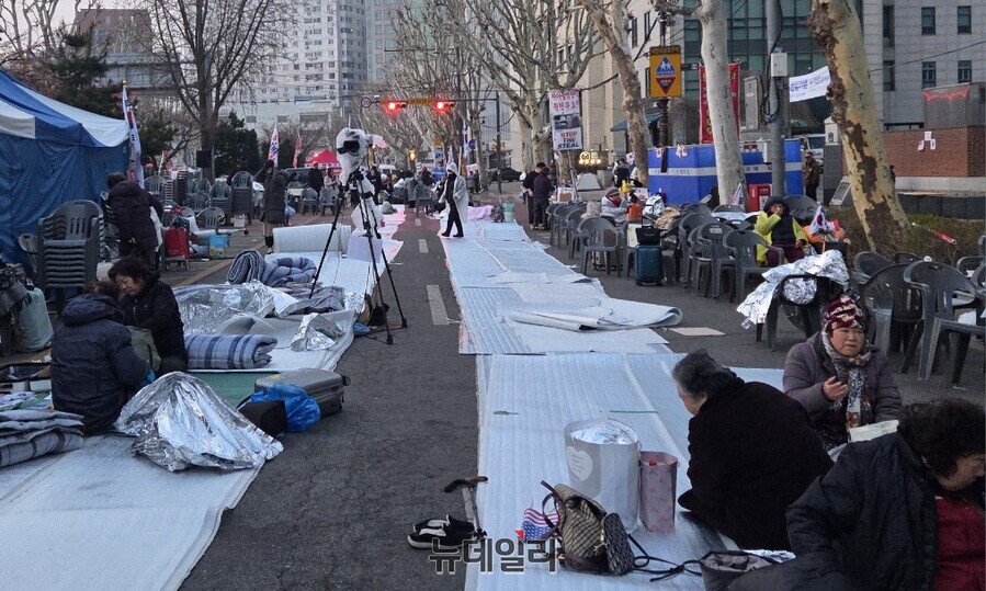 ▲ 3일 새벽 안국역 5번 출구 인근에서 시민들이 4월에도 패딩을 입고 모자를 눌러쓴 채 바닥에 앉아 철야 농성을 이어가고 있다. ⓒ박서아 기자