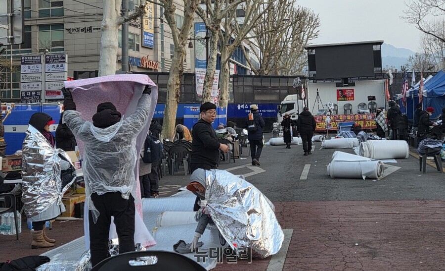▲ 동이 트자 시민들은 바닥에 깔아둔 비닐을 정리하고 낮 집회를 위해 의자를 설치하는 등 자리를 정돈하기 시작했다. ⓒ박서아 기자