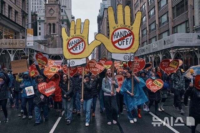 ▲ 미국 뉴욕에서 도널드 트럼프 대통령과 일론 머스크 정부효율부 수장에 반대하는 '핸즈 오프!(Hands Off!)' 집회가 열려 참가자들이 구호를 외치며 행진하고 있다. 250405 AP/뉴시스. ⓒ뉴시스