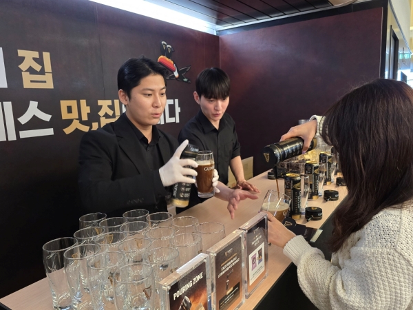 ▲ 나이트로서지 디바이스를 전용 캔에 끼워 기네스를 따르는 모습ⓒ최신혜 기자