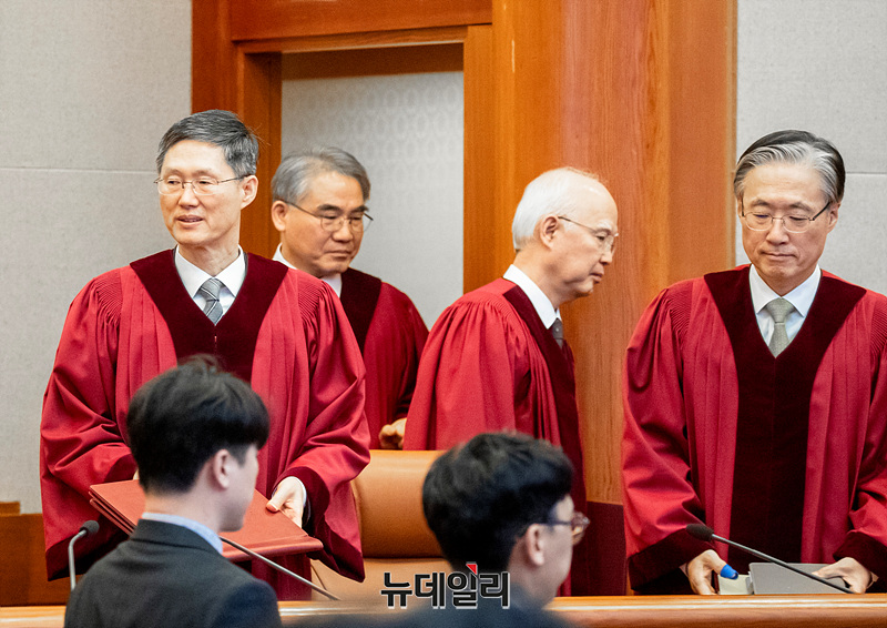 ▲ 윤석열 대통령 탄핵 선고를 위해 재판정에 들어서는 헙법재판관들 모습. 헌재소장 대행 문형배의 얼굴 표정이 환하게 밝다. 헌법수호가 아니라 국회 이재명당 주도《연성쿠데타》에 전원이 부역·동조키로 결의한 탓이리라. 결론에 꿰맞춘 법리를 창작하느라 애썼는지 주심 정형식은 고개를 숙이고 입장하고 있다. ⓒ 사진=공동취재단