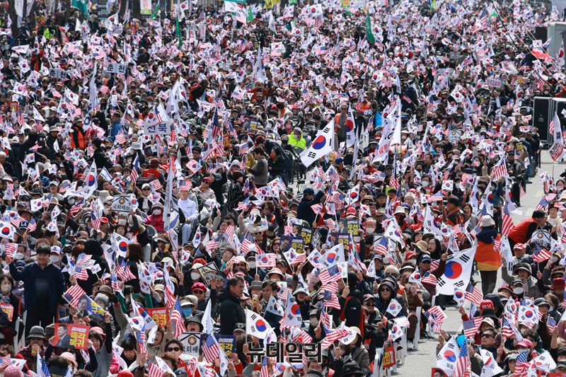 ▲ 지난달 15일 광화문 일대에서 대한민국바로세우기운동본부 주최로 열린 '윤석열 대통령 탄핵 반대 국민대회'에 참석한 시민들이 태극기와 성조기를 흔들고 있다. ⓒ이종현 기자